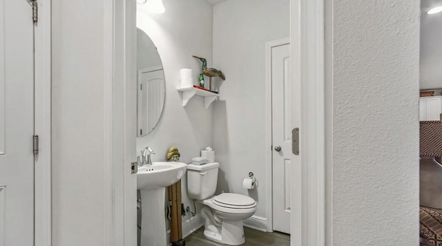 bathroom featuring toilet and wood finished floors