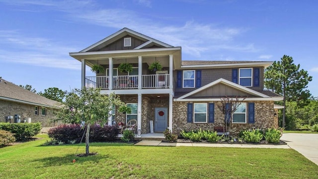 view of front of house featuring brick siding, board and batten siding, a front yard, and a balcony