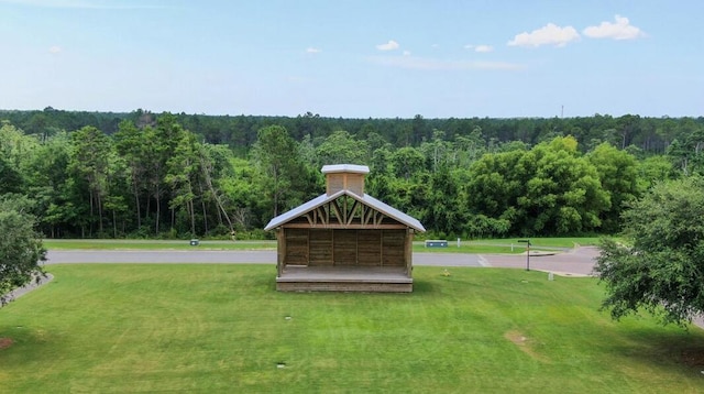 surrounding community with a view of trees and a yard