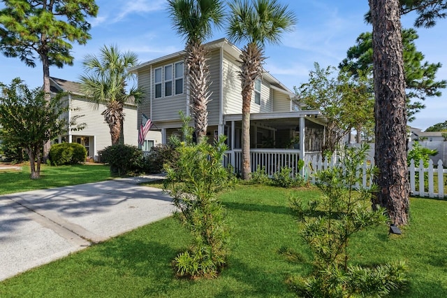 view of front facade featuring a front yard and a sunroom