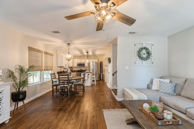 living room with dark hardwood / wood-style floors and ceiling fan with notable chandelier