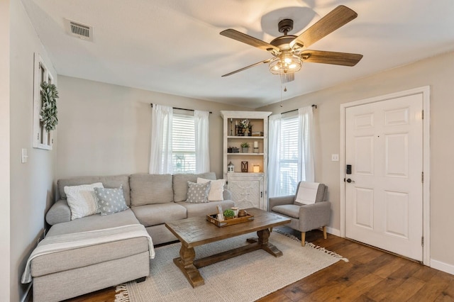 living room featuring ceiling fan, plenty of natural light, and dark hardwood / wood-style flooring