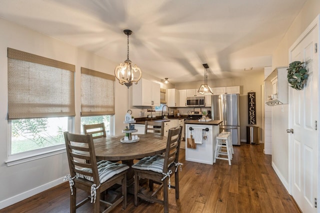 dining room with dark wood-type flooring, sink, and an inviting chandelier