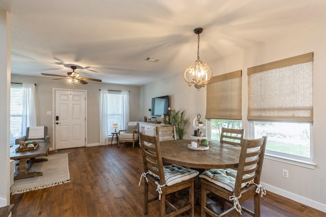 dining space with dark wood-type flooring and ceiling fan with notable chandelier