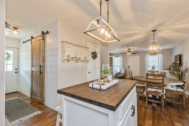 kitchen with butcher block counters, a kitchen island, a barn door, and a healthy amount of sunlight