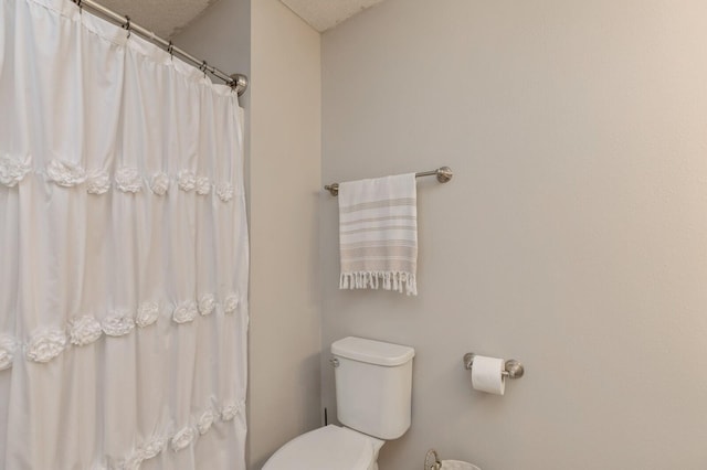 bathroom featuring a textured ceiling and toilet