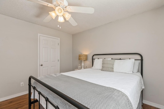 bedroom with ceiling fan, dark hardwood / wood-style floors, and a textured ceiling