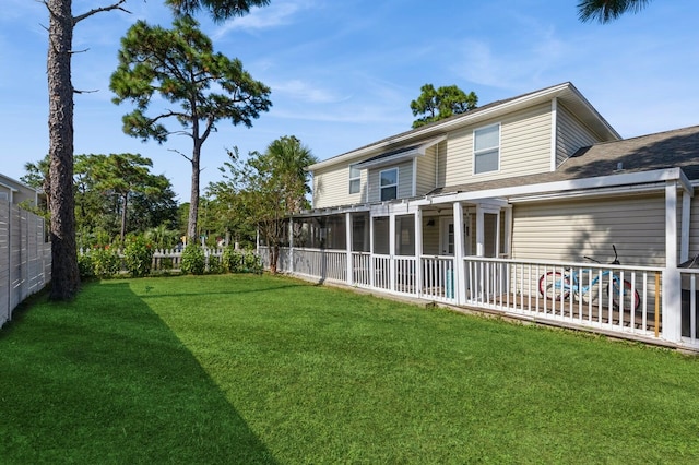 rear view of property with a sunroom and a lawn