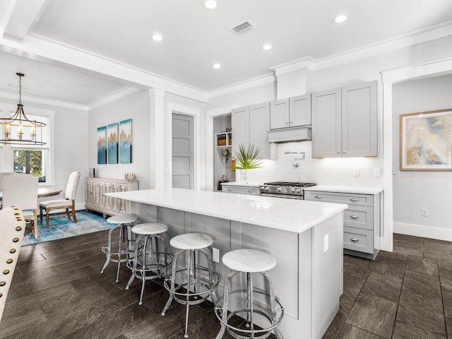 kitchen featuring a breakfast bar area, pendant lighting, stainless steel range, and a center island