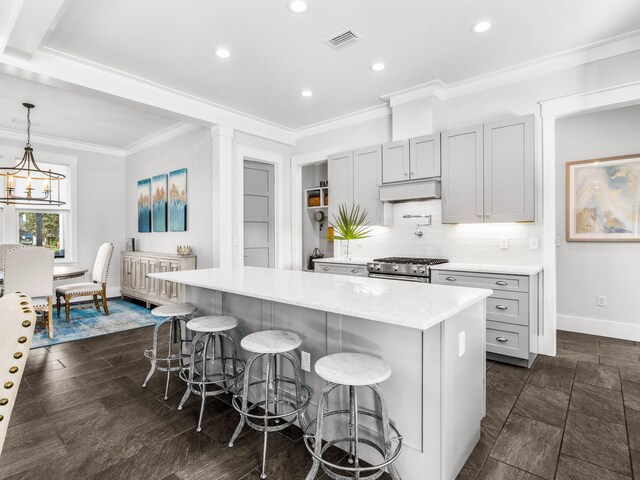 968 Don Bishop Rd, Santa Rosa Beach, FL 32459 - kitchen with stainless steel stove, ornamental molding, baseboards, a kitchen breakfast bar, and a kitchen island
