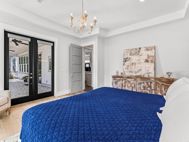 bedroom featuring an inviting chandelier, access to outside, hardwood / wood-style floors, and french doors