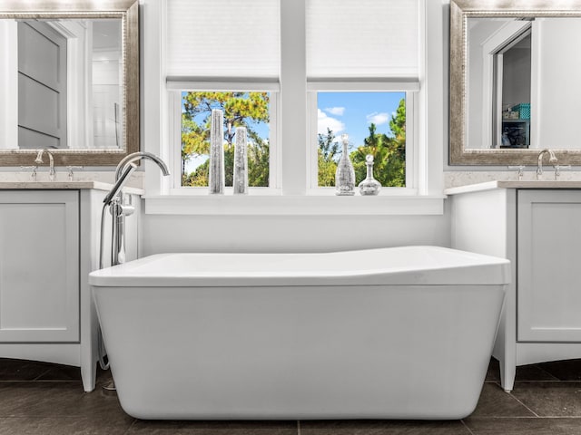 bathroom with tile patterned flooring, vanity, and a tub to relax in