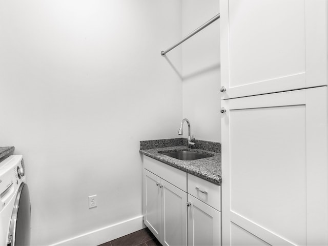 washroom with cabinets, dark tile patterned flooring, and sink