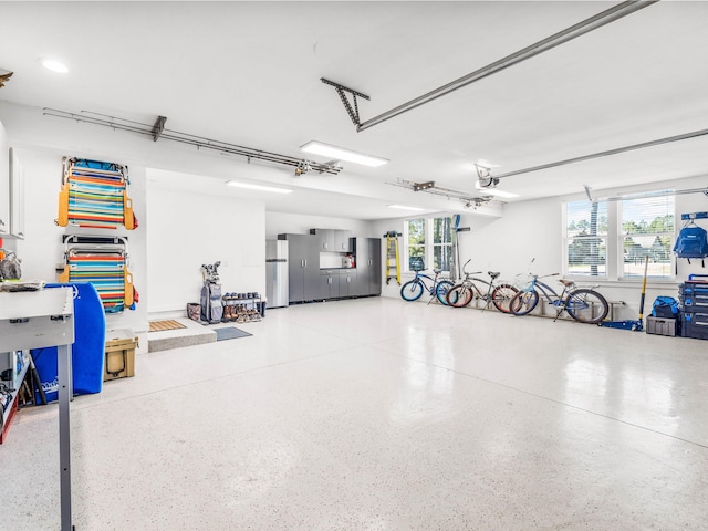 garage with a garage door opener and stainless steel fridge