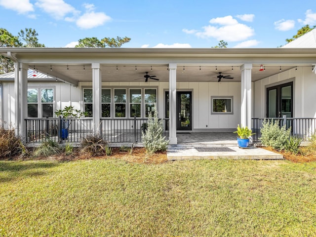 rear view of property featuring a lawn, covered porch, and ceiling fan