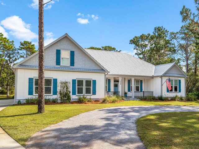 968 Don Bishop Rd, Santa Rosa Beach, FL 32459 - view of front of property featuring covered porch, curved driveway, board and batten siding, a front lawn, and metal roof