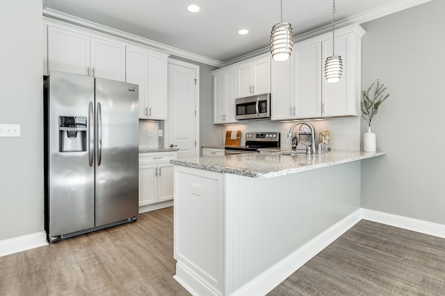 kitchen featuring sink, hanging light fixtures, stainless steel appliances, light hardwood / wood-style floors, and white cabinets