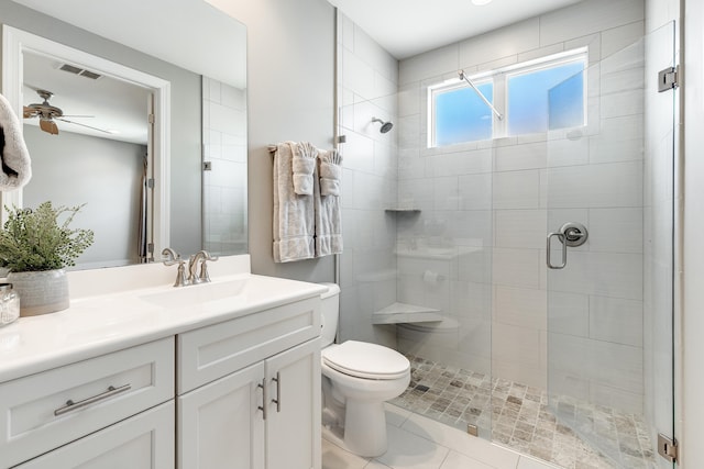 bathroom featuring vanity, tile patterned floors, ceiling fan, toilet, and an enclosed shower