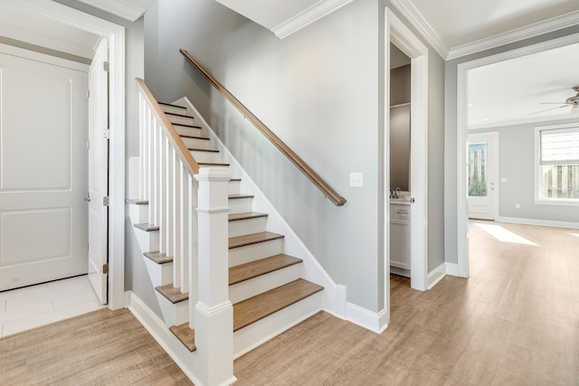 stairs with wood-type flooring, ceiling fan, and crown molding