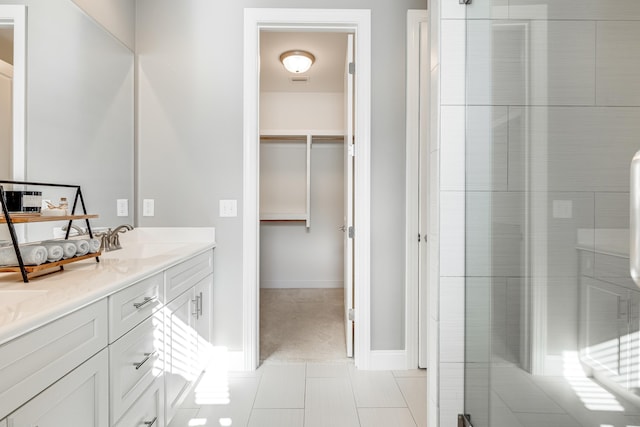 bathroom with tile patterned flooring, vanity, and a shower with shower door