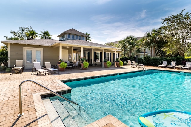 view of swimming pool featuring french doors, a patio, and ceiling fan