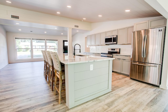 kitchen featuring gray cabinetry, stainless steel appliances, vaulted ceiling, sink, and light hardwood / wood-style floors