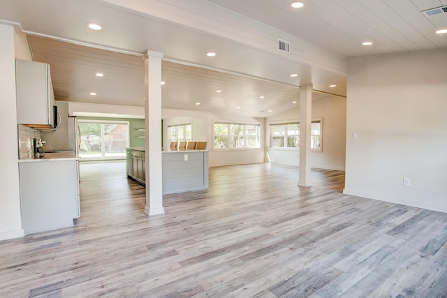 unfurnished living room with light wood-type flooring and a wealth of natural light