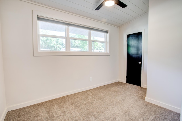 empty room with carpet, vaulted ceiling, ceiling fan, and a healthy amount of sunlight