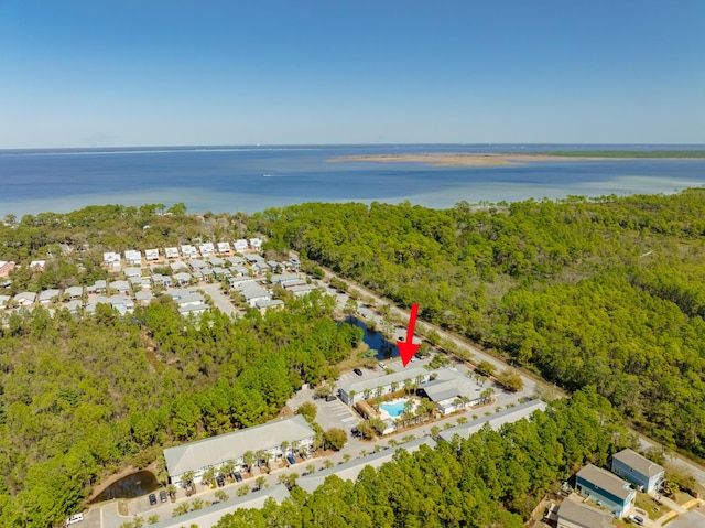 aerial view featuring a wooded view and a water view