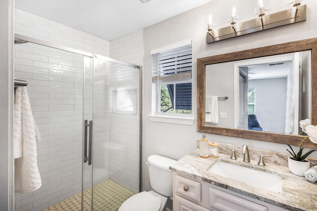 full bathroom with a stall shower, toilet, and vanity