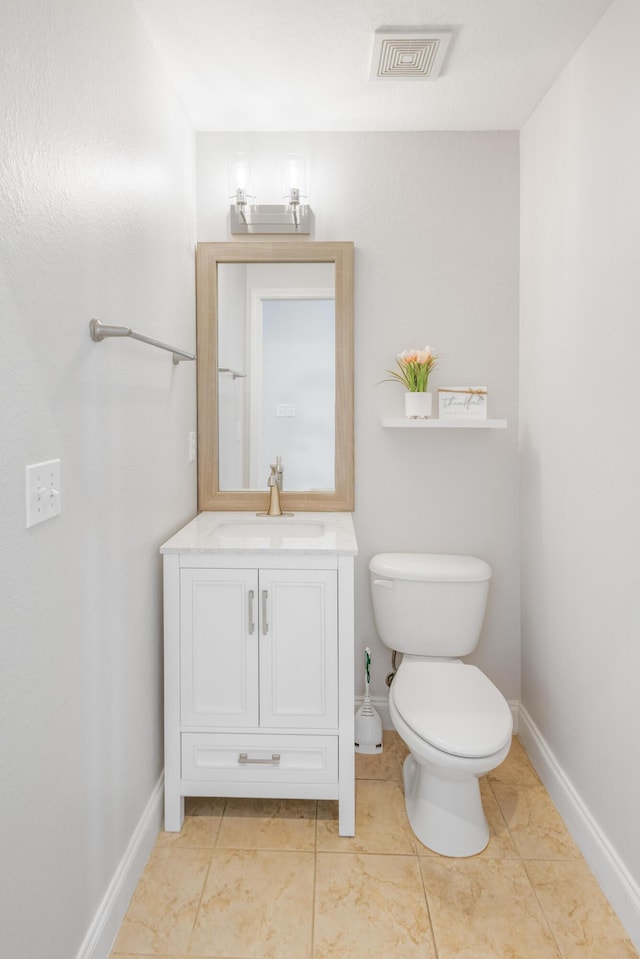 half bathroom featuring visible vents, toilet, vanity, and baseboards