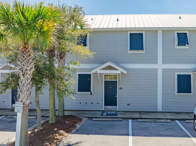 view of front of house with a standing seam roof, uncovered parking, and metal roof