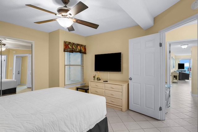 tiled bedroom featuring ceiling fan