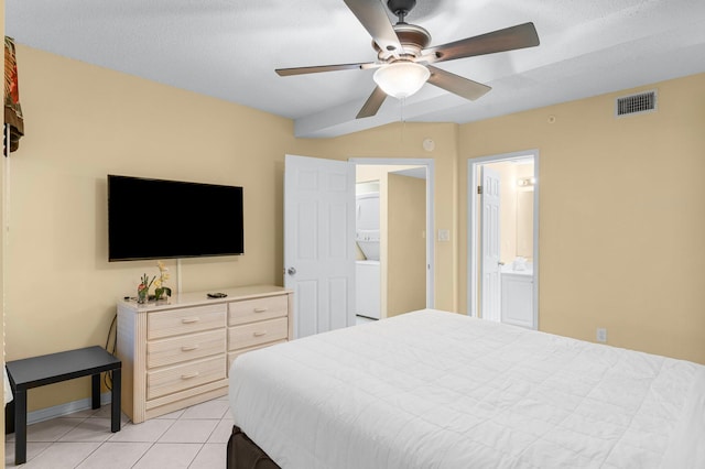 tiled bedroom with a textured ceiling, connected bathroom, and ceiling fan