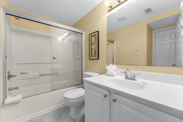 full bathroom with tile patterned flooring, a textured ceiling, toilet, shower / bath combination with glass door, and vanity