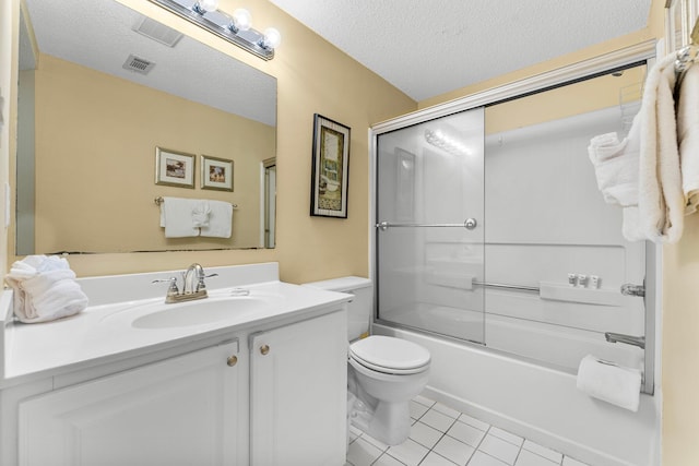 full bathroom featuring vanity, combined bath / shower with glass door, tile patterned flooring, toilet, and a textured ceiling