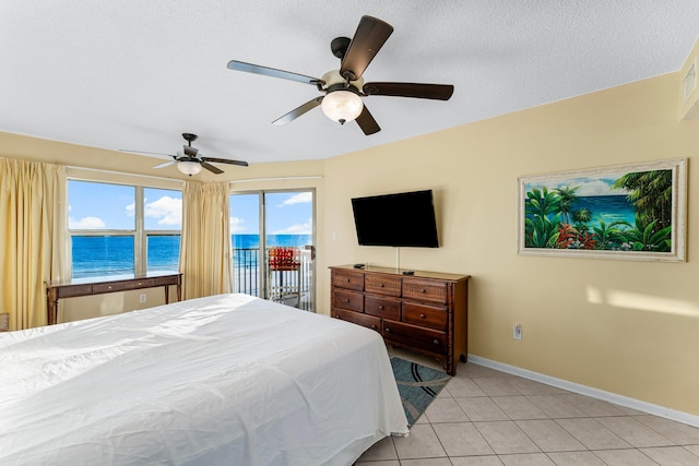 tiled bedroom with access to exterior, a textured ceiling, and ceiling fan