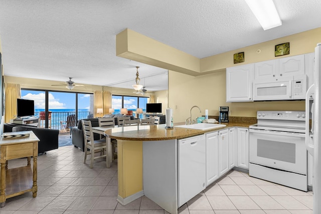 kitchen with white cabinetry, sink, kitchen peninsula, a textured ceiling, and white appliances