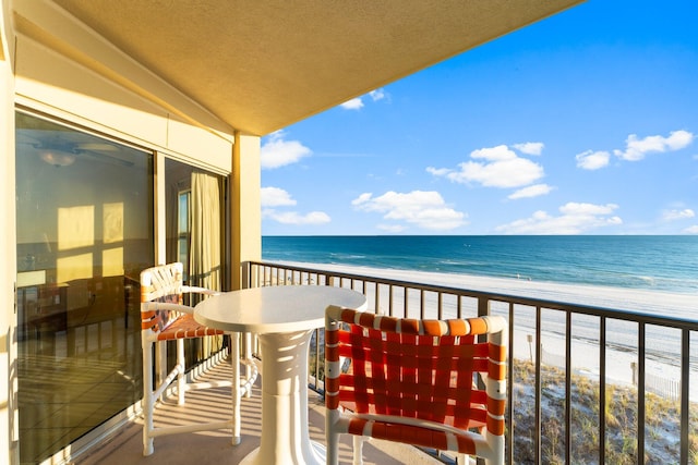 balcony featuring a water view and a beach view