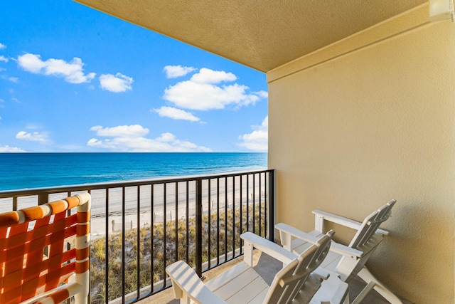 balcony featuring a beach view and a water view