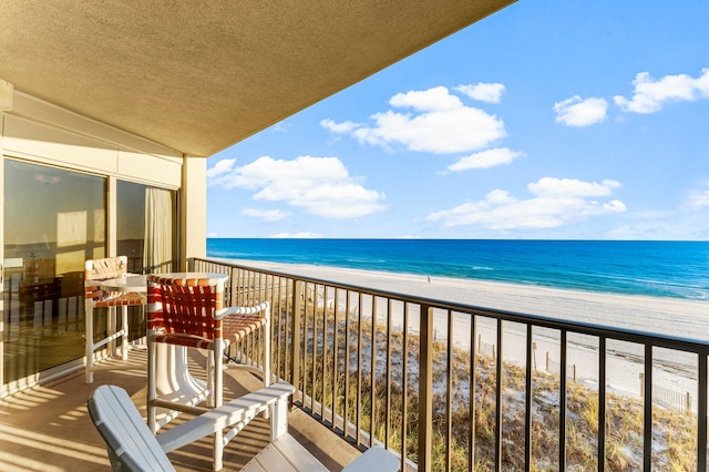 balcony with a water view and a beach view