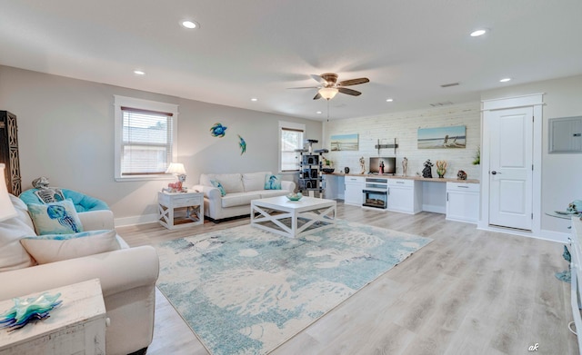 living room with ceiling fan and light hardwood / wood-style flooring