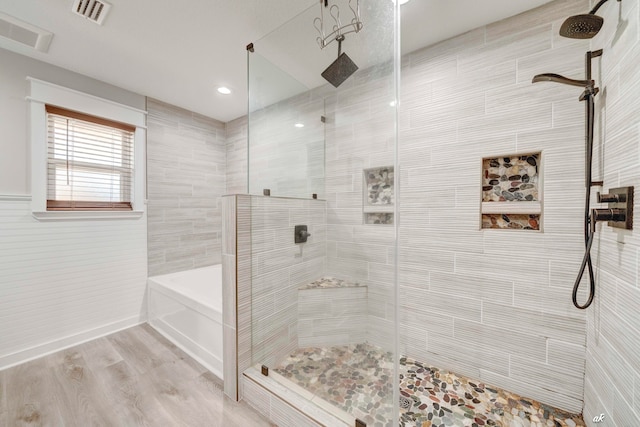 bathroom with hardwood / wood-style floors and separate shower and tub