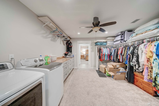 laundry area featuring light colored carpet, ceiling fan, and washer and dryer