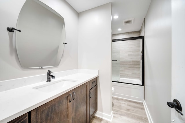 248 Sukoshi Dr, Panama City, FL 32404 - full bath with toilet, wood finished floors, vanity, shower / bath combination with glass door, and baseboards