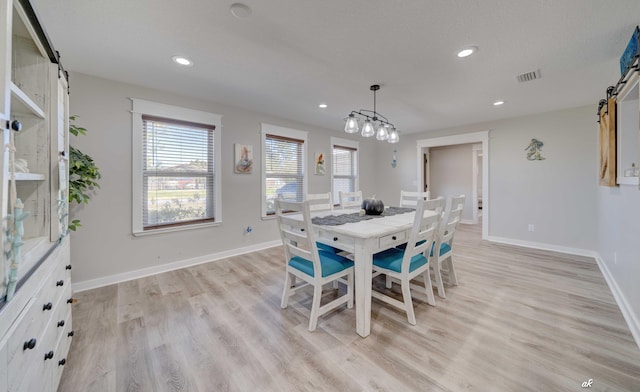 248 Sukoshi Dr, Panama City, FL 32404 - dining room featuring a barn door, light wood finished floors, baseboards, and recessed lighting