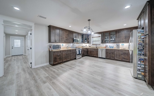 248 Sukoshi Dr, Panama City, FL 32404 - kitchen with stainless steel appliances, a sink, dark brown cabinetry, light wood-style floors, and baseboards