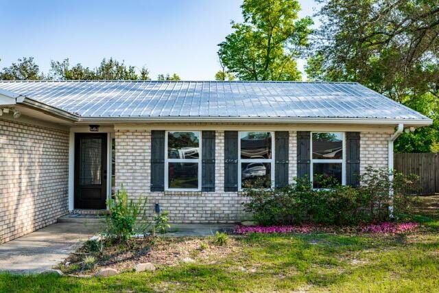 248 Sukoshi Dr, Panama City, FL 32404 - ranch-style house featuring brick siding, metal roof, and fence