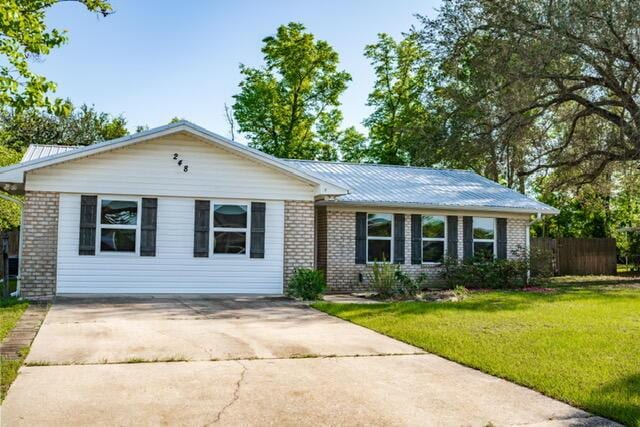 248 Sukoshi Dr, Panama City, FL 32404 - ranch-style house featuring brick siding, driveway, and metal roof