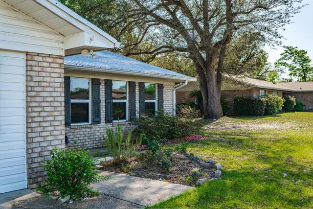 248 Sukoshi Dr, Panama City, FL 32404 - view of property exterior featuring a lawn and brick siding